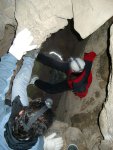 Erin working her way down a chimney just below the mouth of the cave.  Jason is below, with Mayela and a bit of Brandon's foot in the foreground.