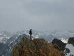 Paul atop the lone spire, with the rest of the Sawtooths stretching out behind him.